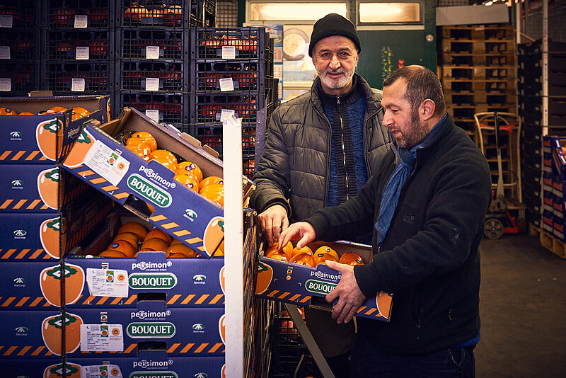 Einkäufer prüft Orangen in der Großmarkthalle